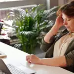 Stressed Jacksonville office worker with back and neck pain from long hours at a desk