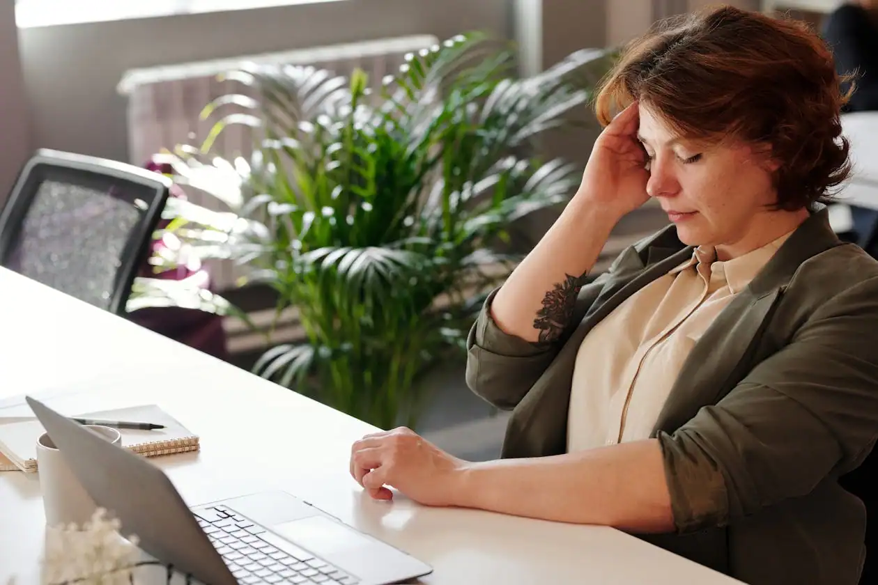 Stressed Jacksonville office worker with back and neck pain from long hours at a desk