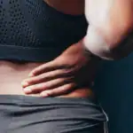 Man holding his lower back in pain from sciatic nerve symptoms