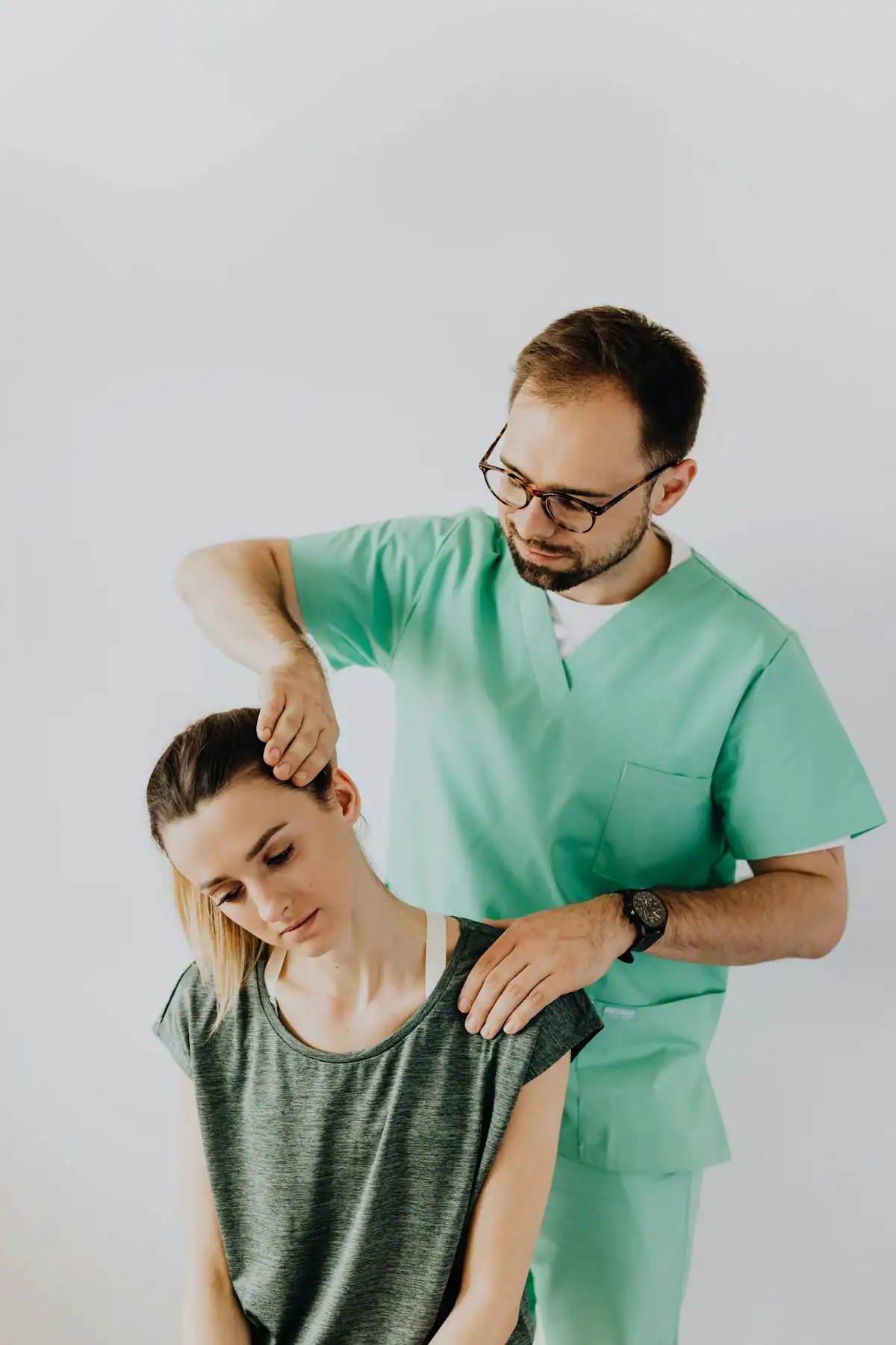 Chiropractor performing a gentle neck adjustment on a patient during a treatment session