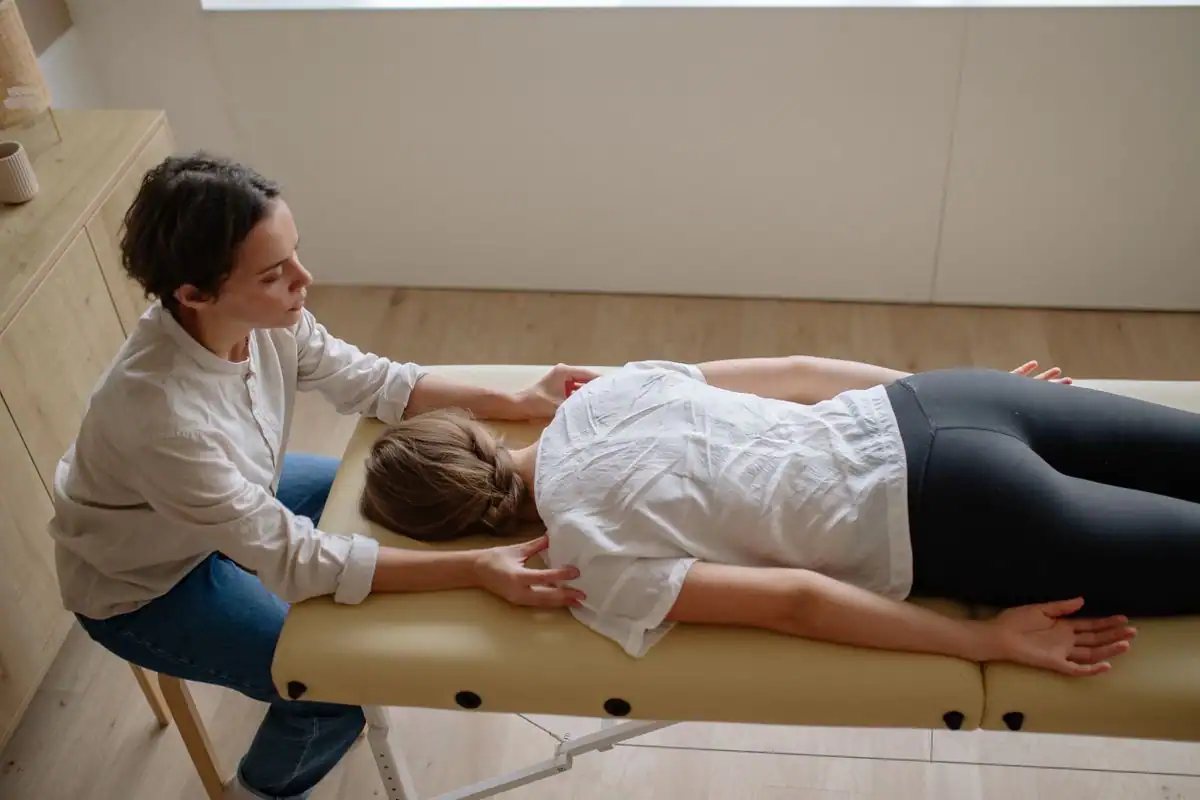 Chiropractor performing a gentle spinal adjustment on a patient lying on a treatment table
