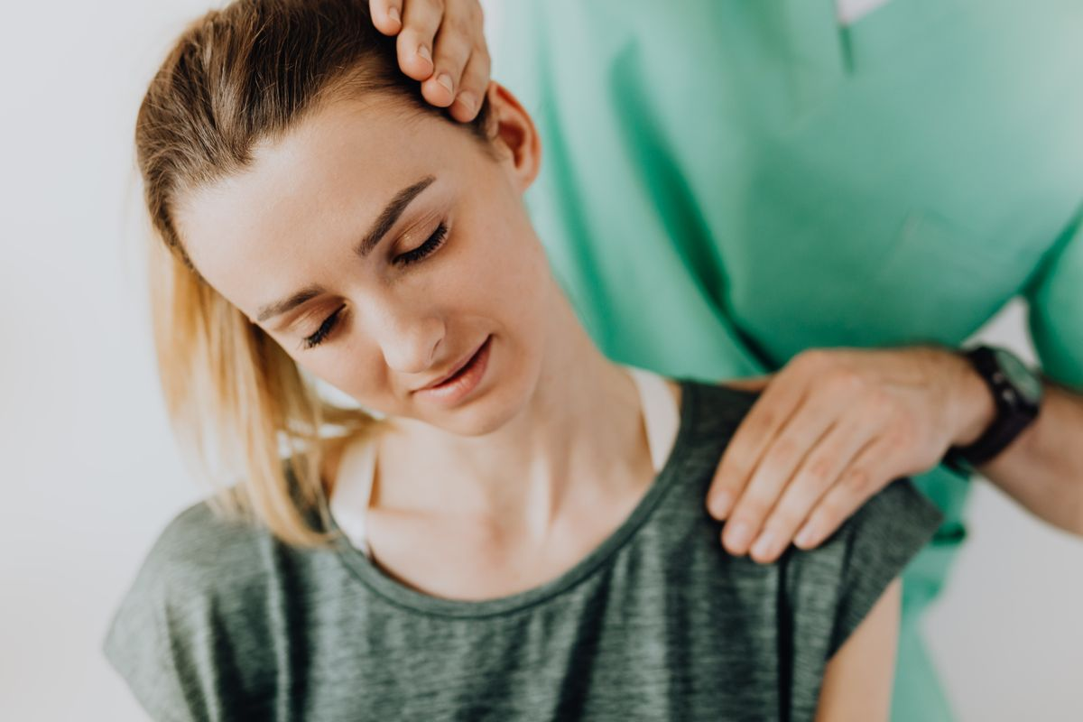 A chiropractor examining and treating a patient's neck on a treatment table