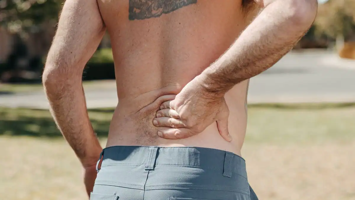 Man holding his lower back in pain, a common reason to see a chiropractor in Jacksonville