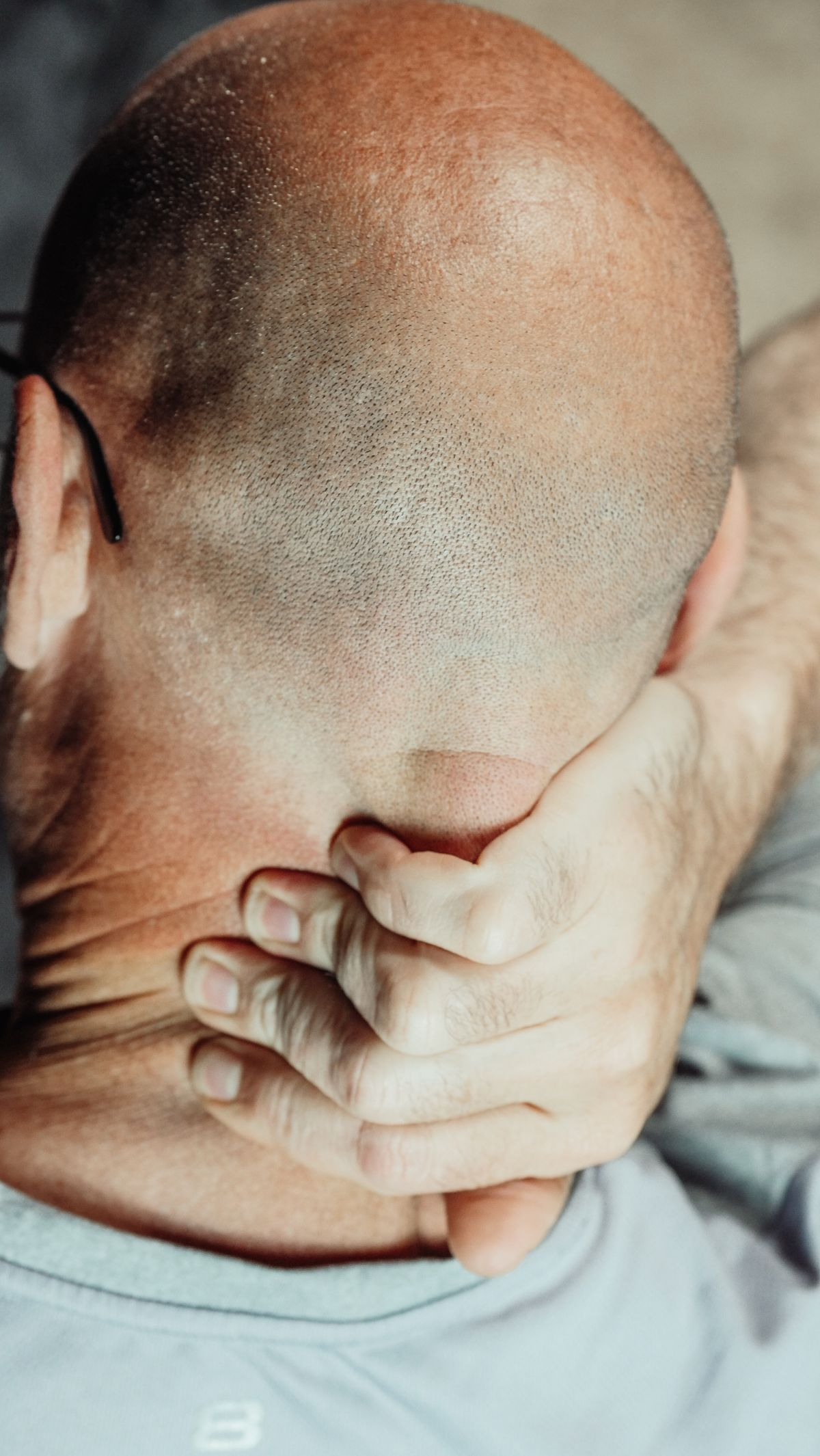 A man rubbing the back of his neck where tension headaches often begin