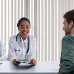A doctor sitting across from a patient and talking through their health history