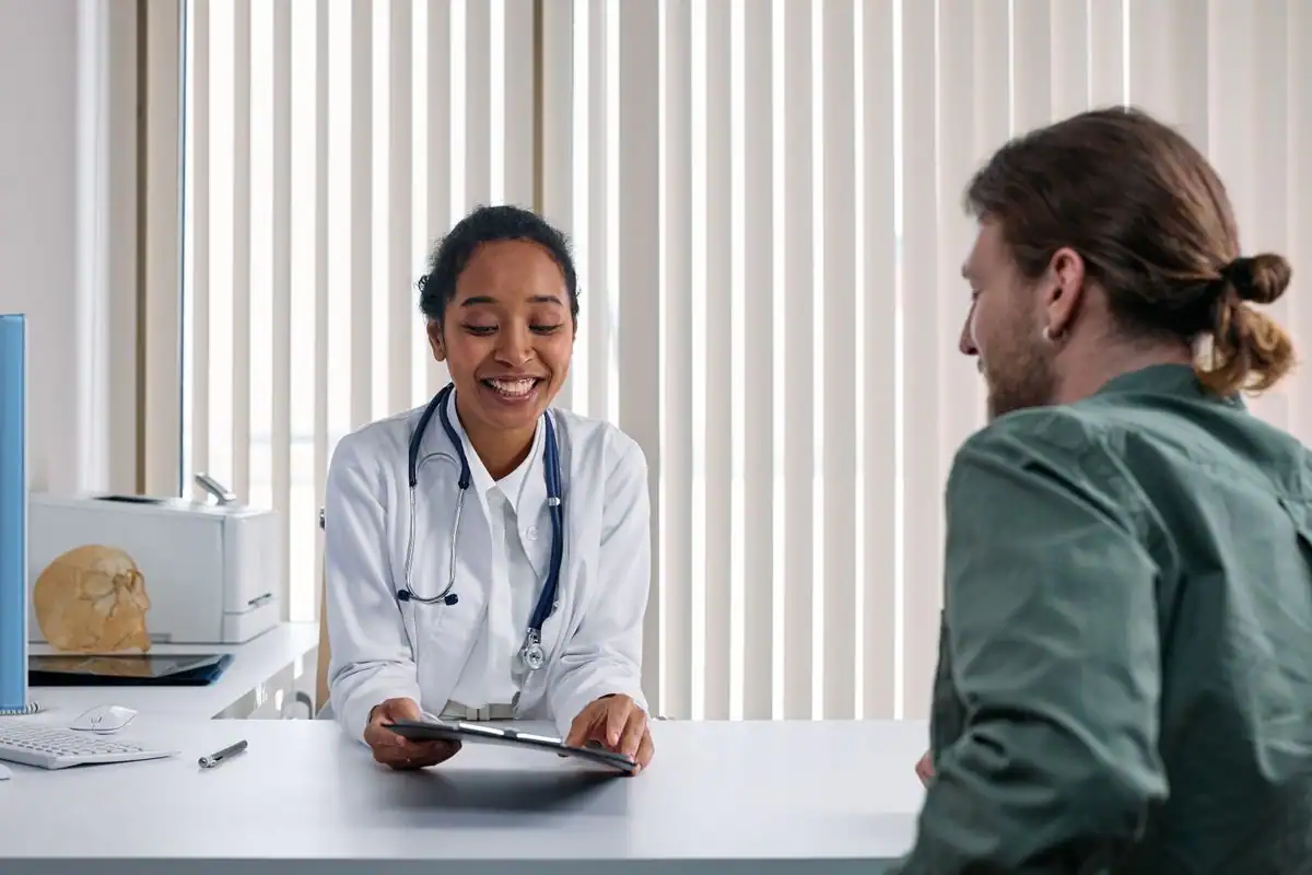 A doctor sitting across from a patient and talking through their health history