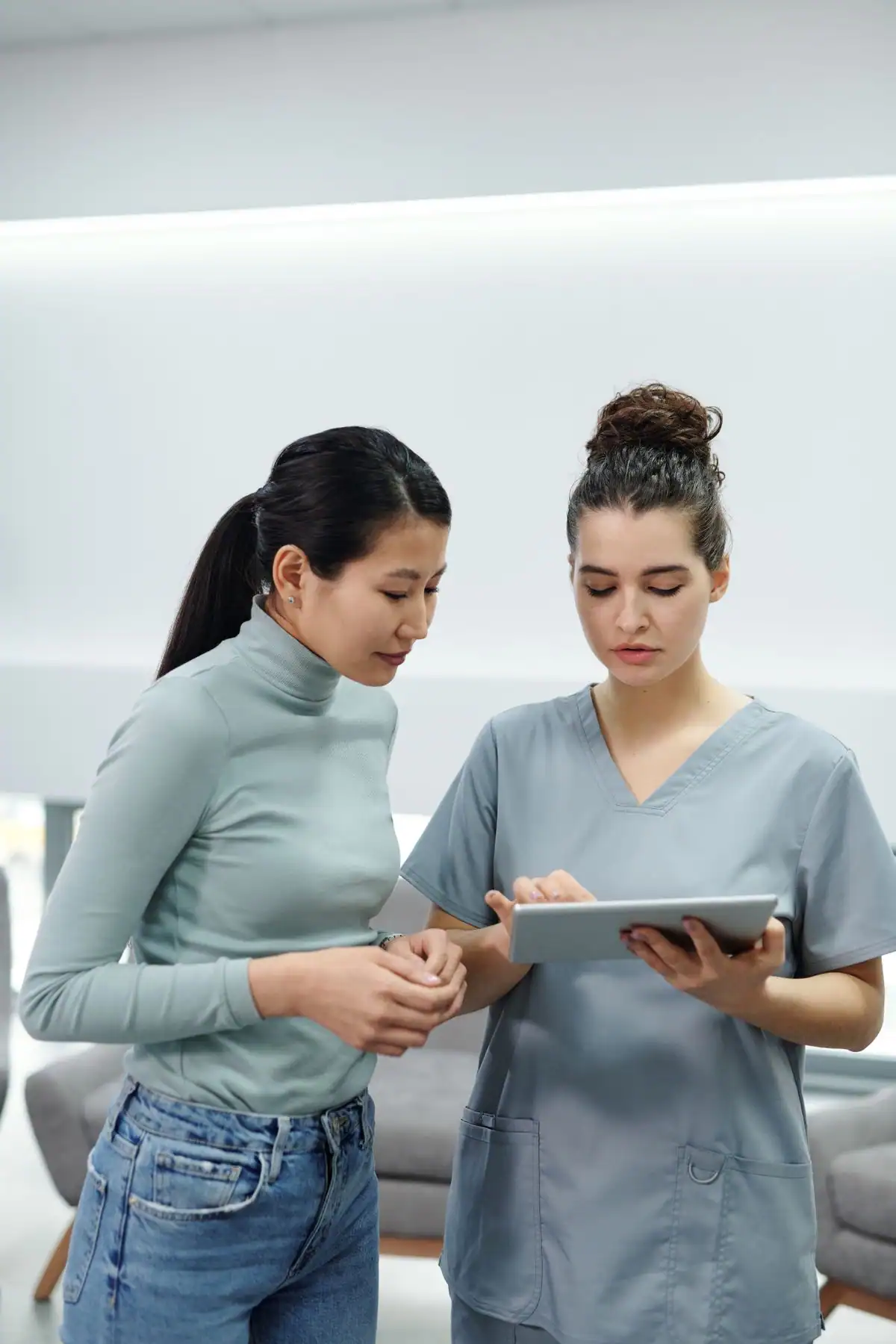 A doctor and patient reviewing exam findings together on a tablet
