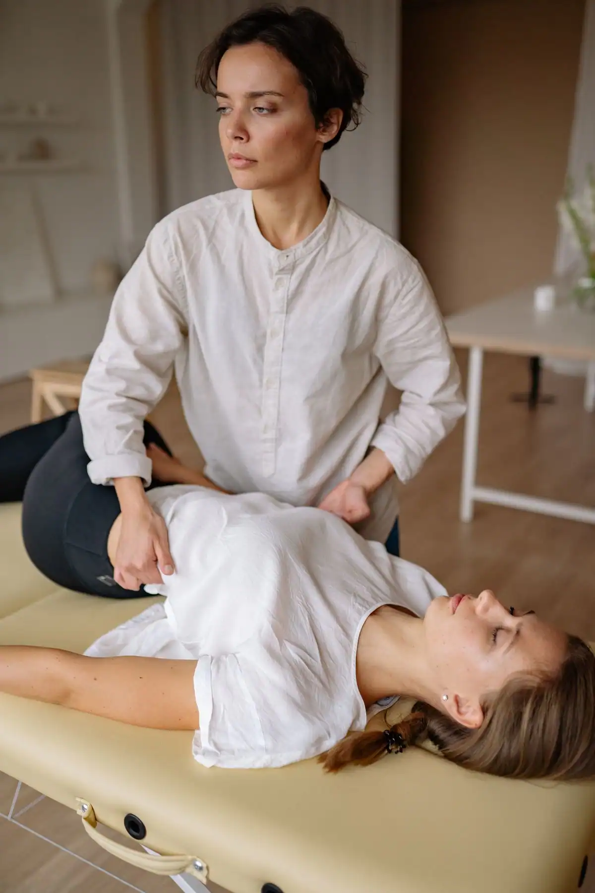 A therapist working on the back of a patient lying on a treatment table