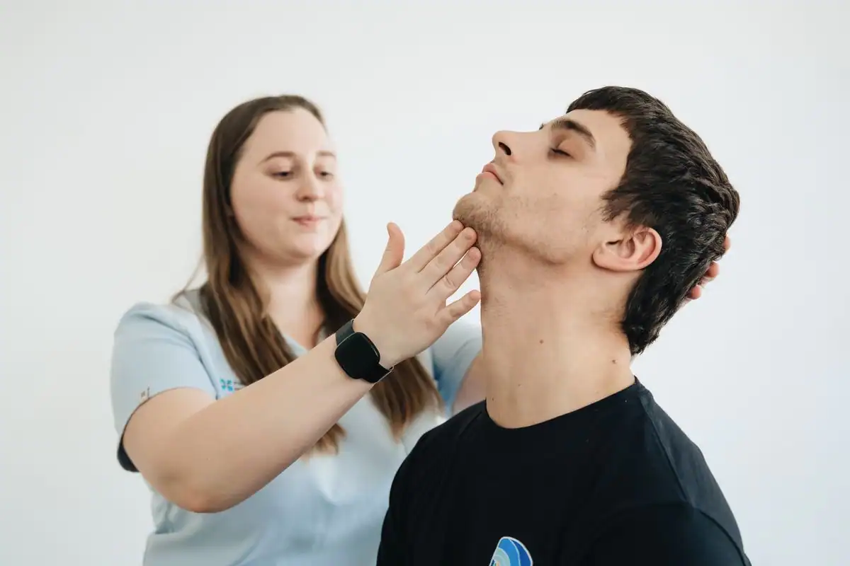 A physiotherapist guiding a patient through gentle neck exercises