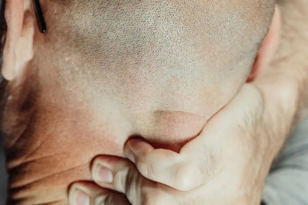 A man rubbing the back of his neck where tension headaches often begin