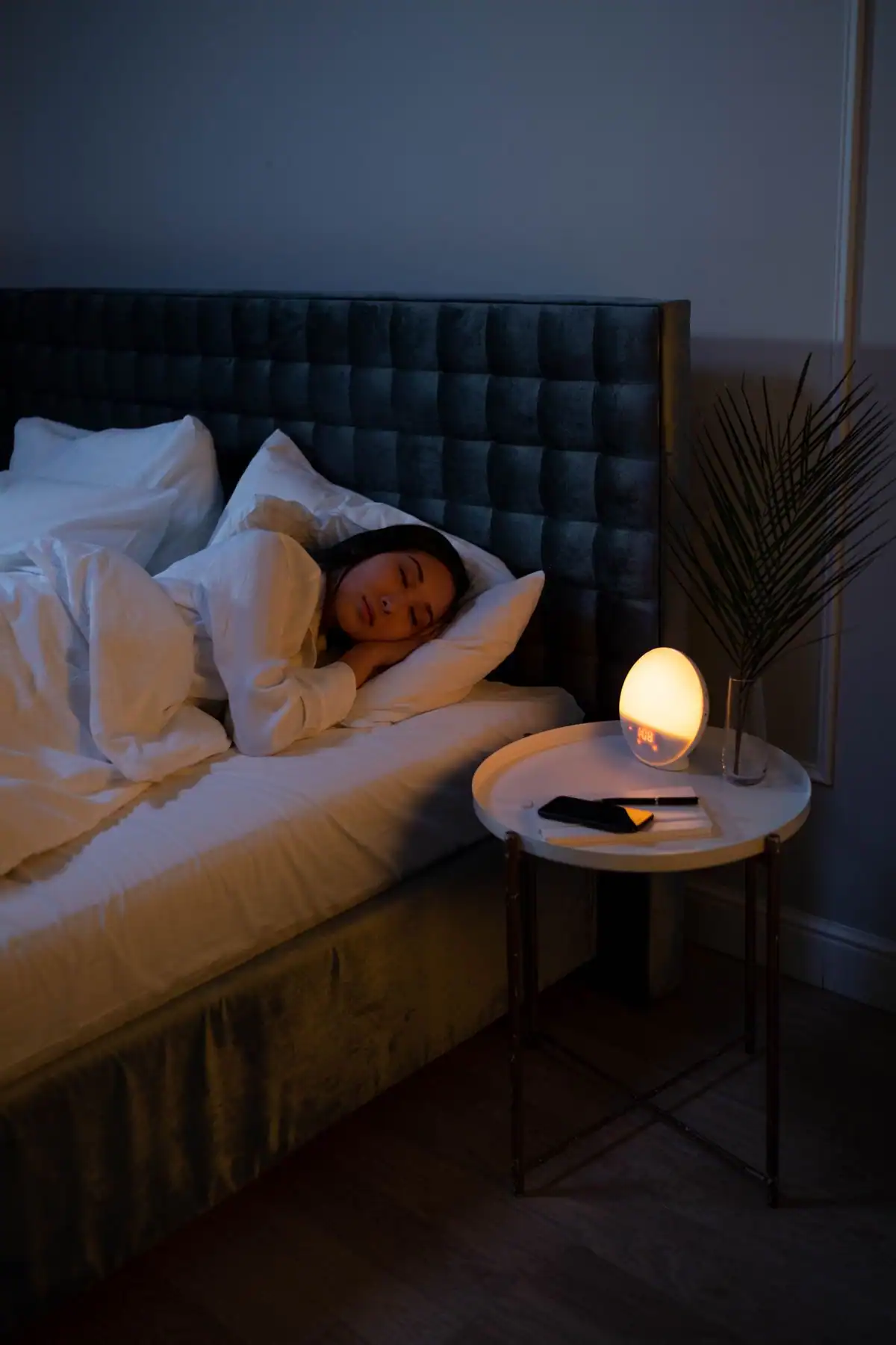 A woman sleeping peacefully in bed at night with soft lighting