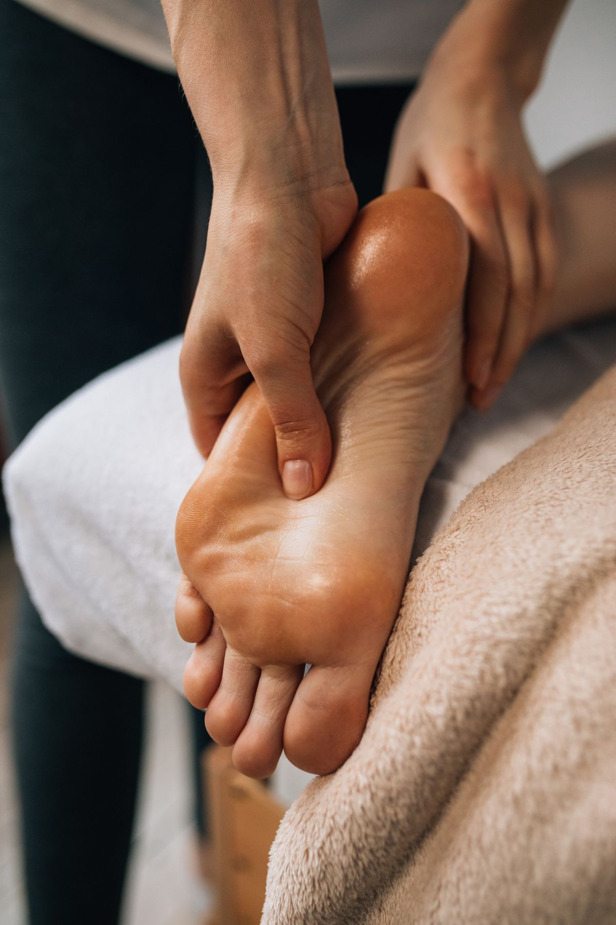 A therapist working on the sole of a patient's foot with both hands