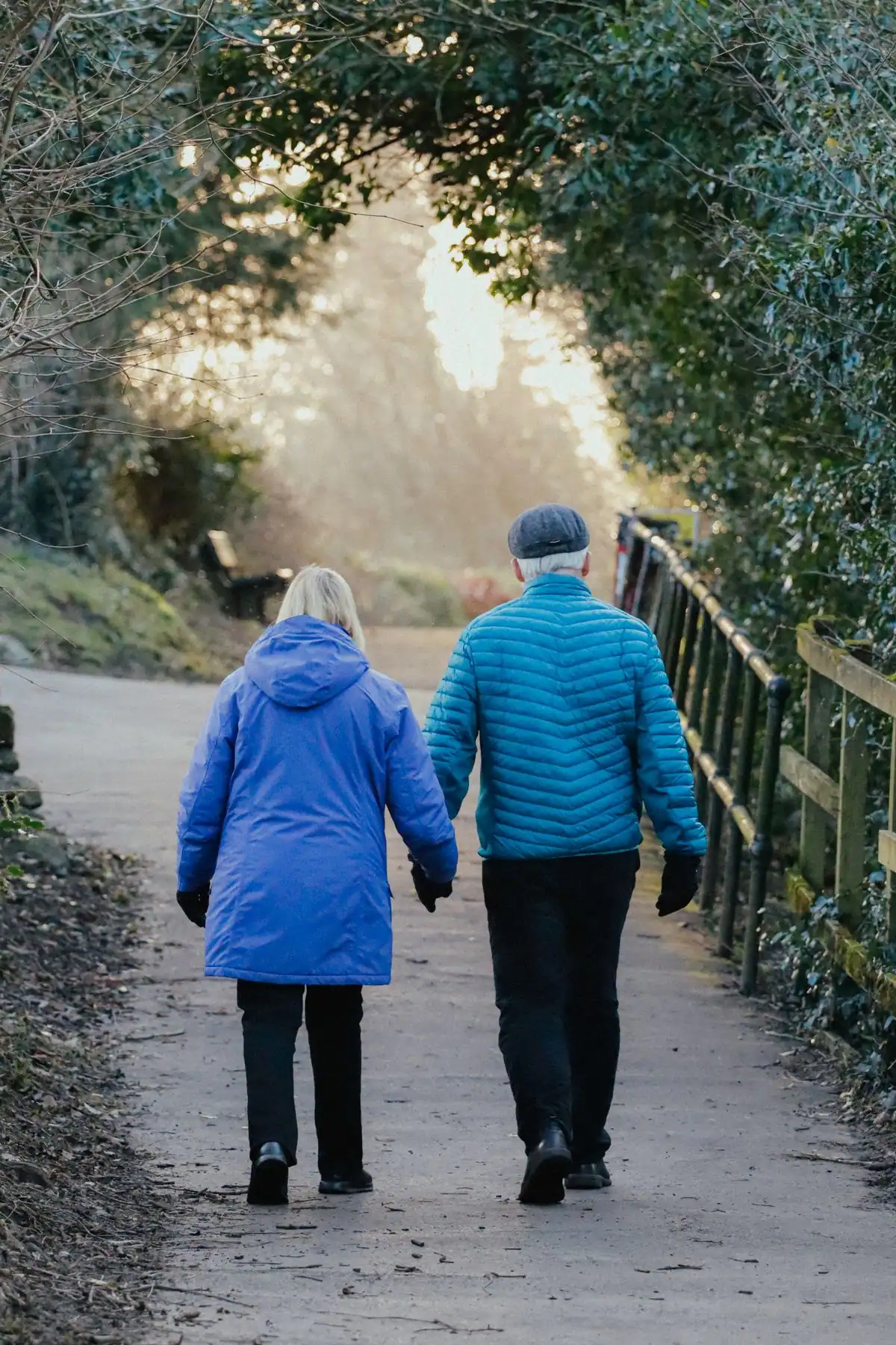 An older couple staying active with a walk through a park